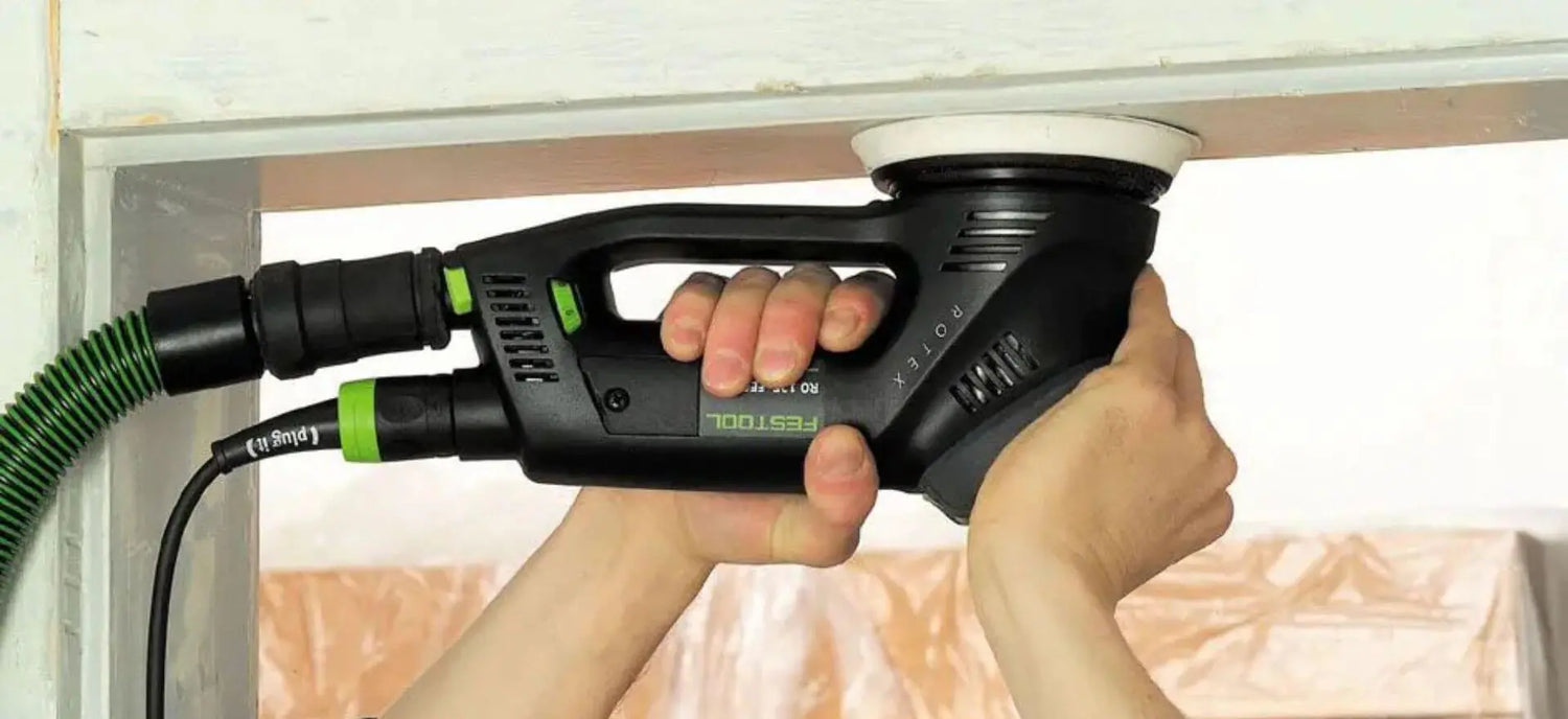 festool sander with hose being used on door frame
