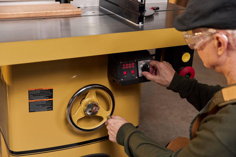 man adjusting powermatic shaper machine