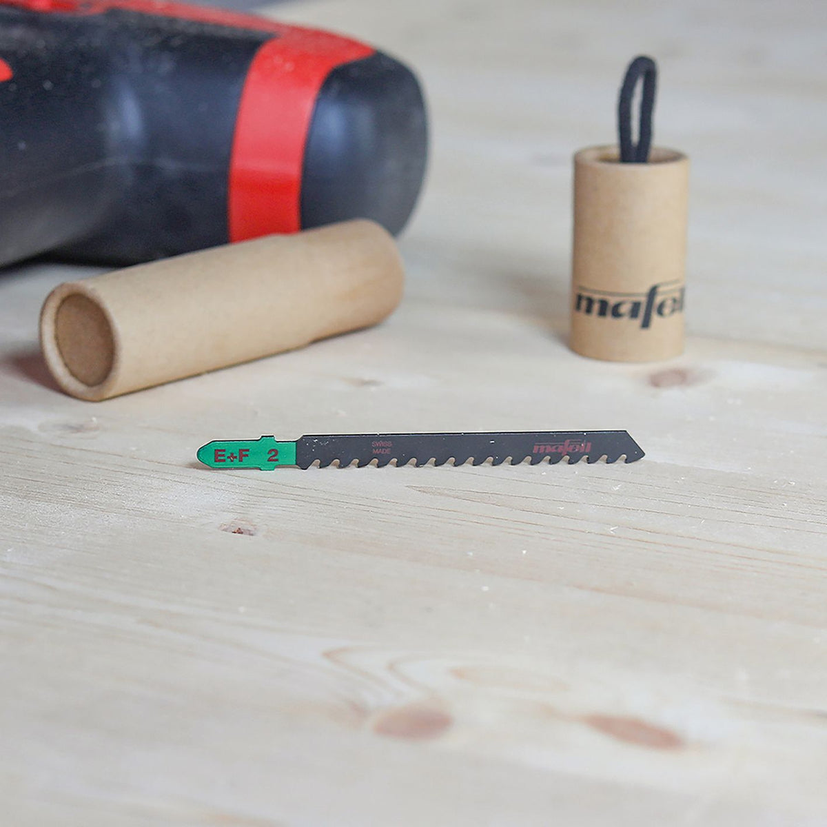 Mafell SSB-EF2 epoxy fiber HM jig saw blade on a wooden workbench with a blurred power tool in the background.