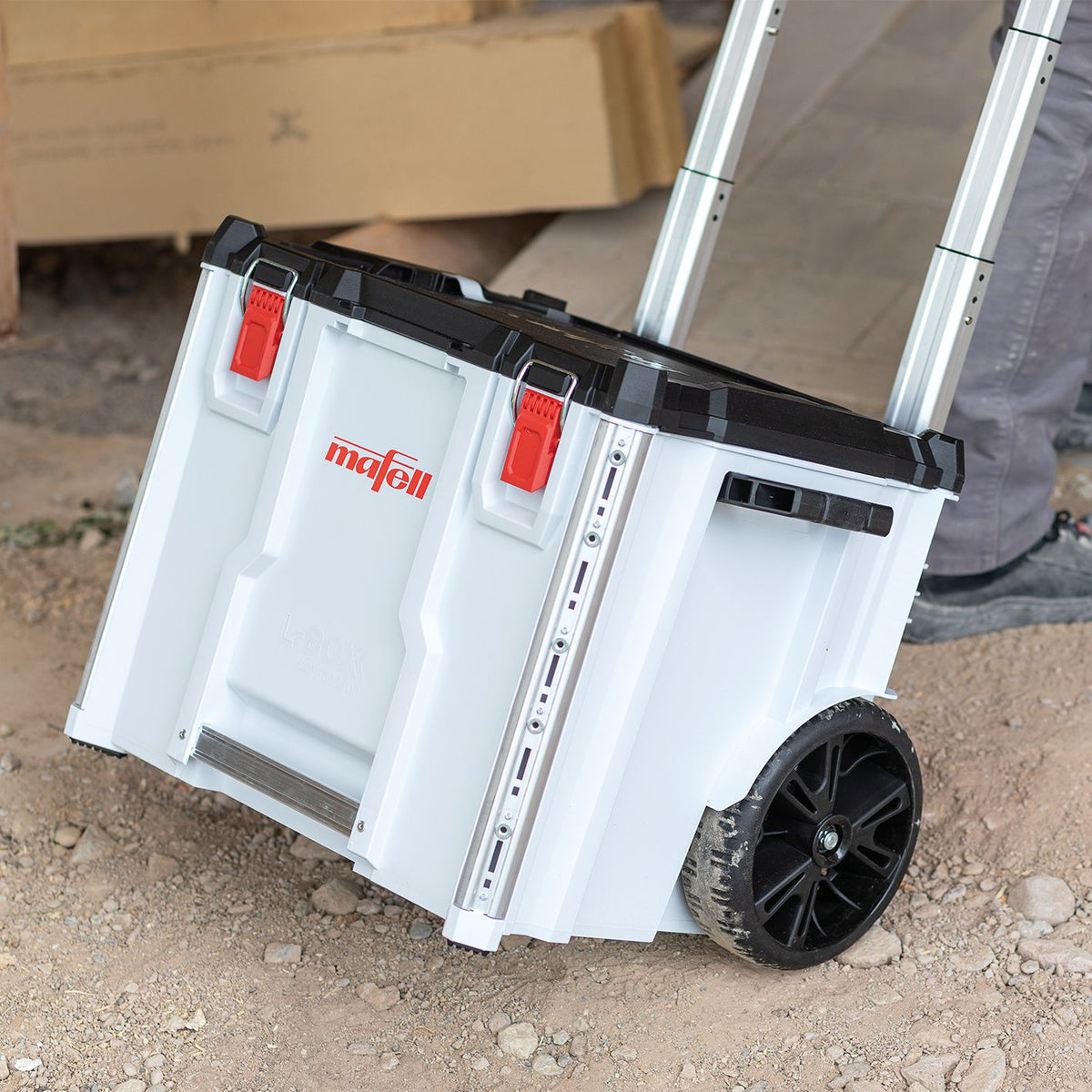 Mafell L-BOXX contractor trolley with extendable handle and red latches being moved toward a work van.
