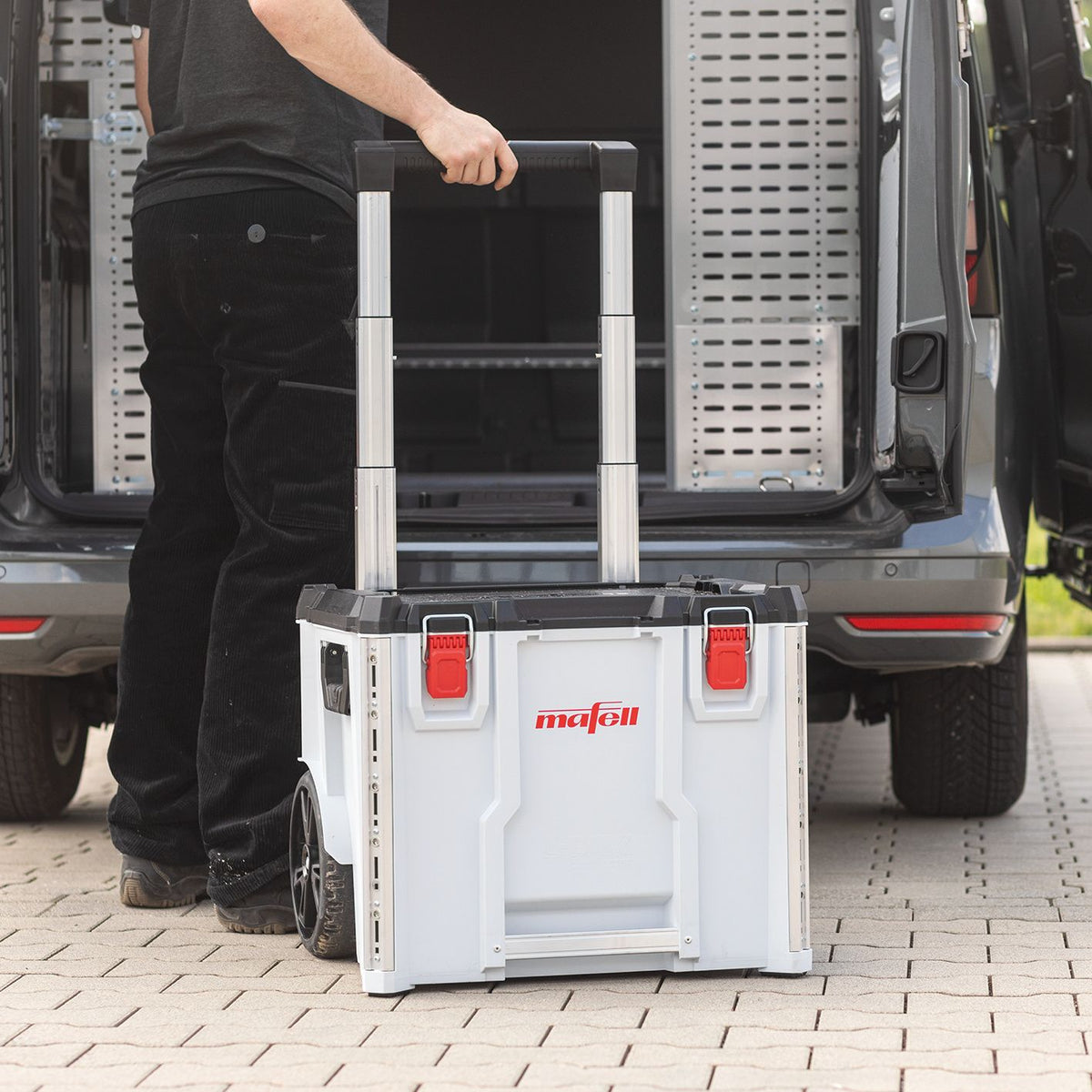 Worker pushes Mafell C476 TB K105 transport case on extendable rails toward a van.