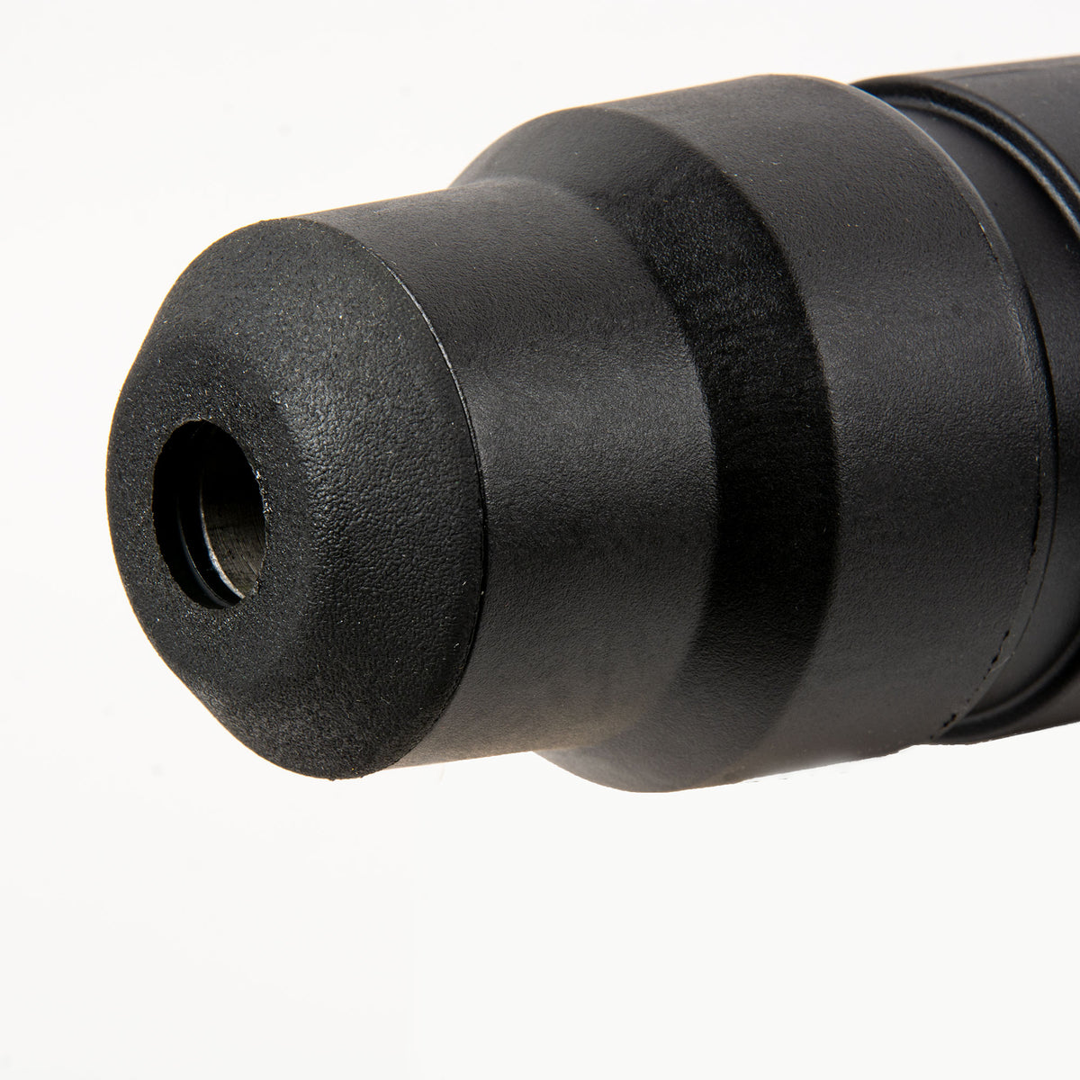Close up of the rotary hammer end with a textured black cylindrical housing and central bore