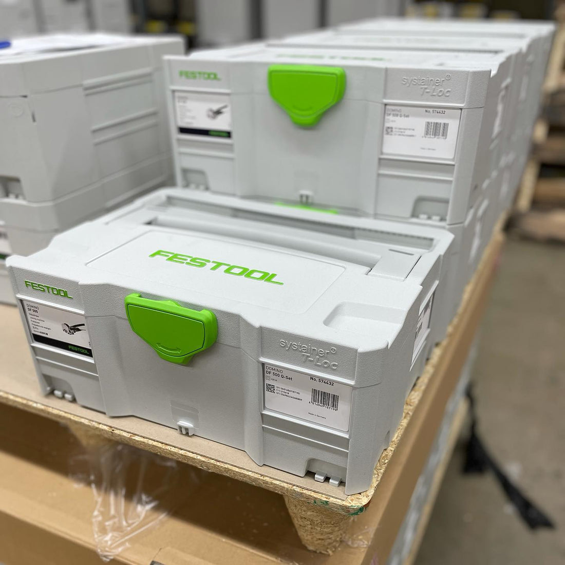 Festool tool boxes stacked on a pallet in a warehouse setting