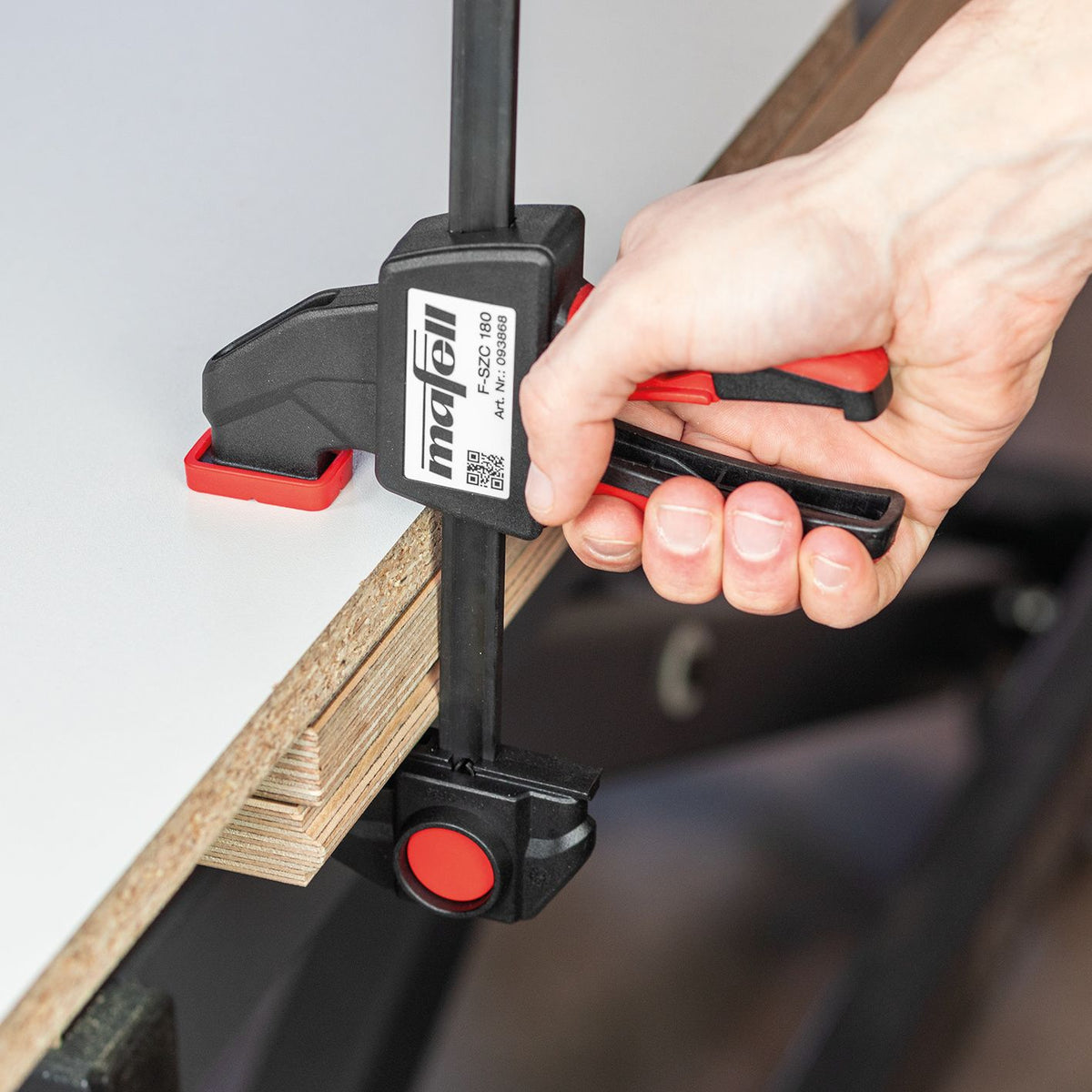 Hands operate a Mafell F-SZC 180 quick lever clamp securing a guide rail to a board