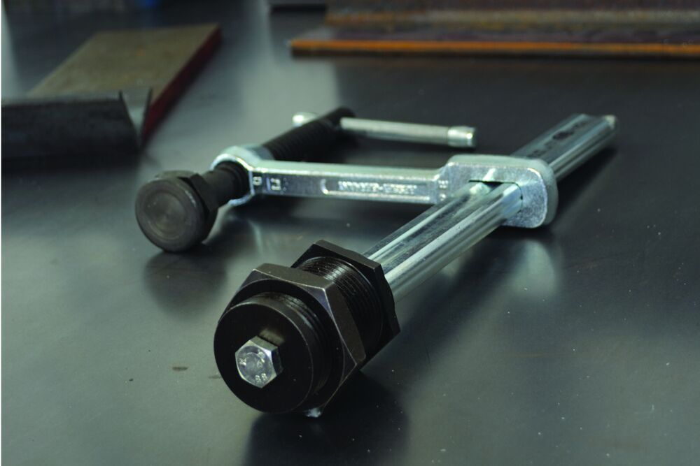 Bessey FC24-8 table fixture hold-down clamp on a metal worktable.