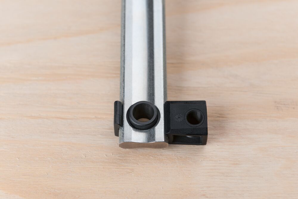 End view of the Bessey K Body REVO clamp showing the black end jaw and silver guide rail.