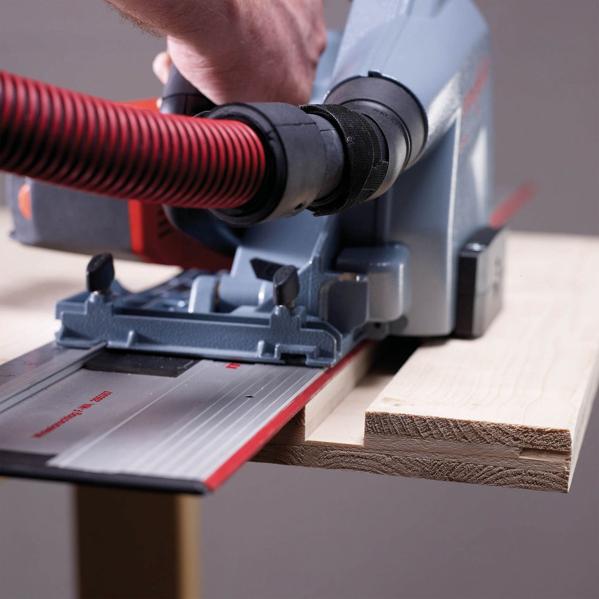 Close-up of Mafell MF-VN 25 groove cutter mounted on MF 26 cc multi-cutter with dust hose and guide rail cutting a groove in wood