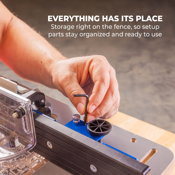 Close-up of the router table fence with built in storage while a hand uses a hex key to adjust components