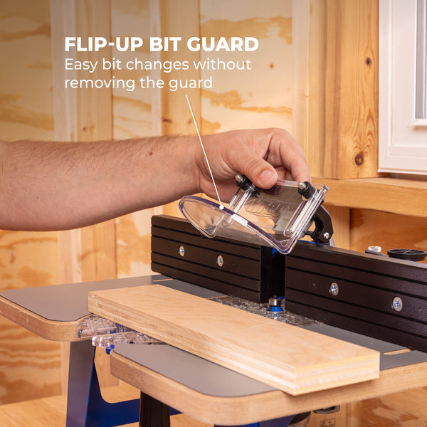 Hand operates a flip-up bit guard on a router table to enable easy bit changes without removing the guard