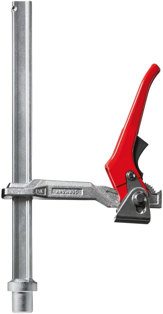 Bessey welding table clamp with red lever handle and serrated jaw attached to a vertical track