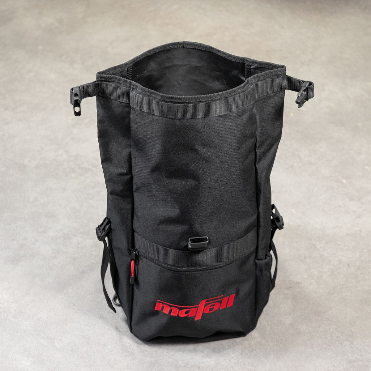 Back view of black Mafell roll-top backpack showing red carrying loop and padded shoulder straps.
