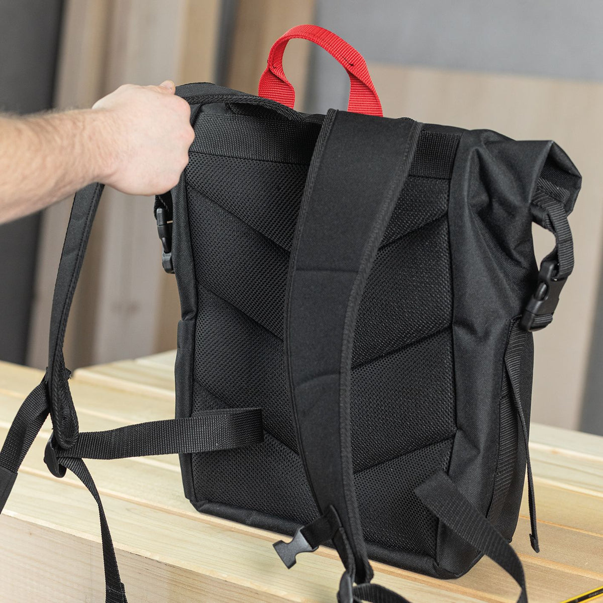 Open top view of black Mafell roll-top backpack with red handle and visible interior.