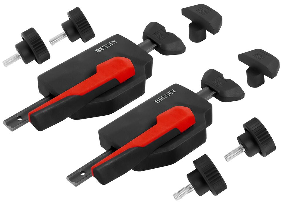 Two BESSEY horizontal fixture clamps with red handles and mounting bolts laid out on a white background