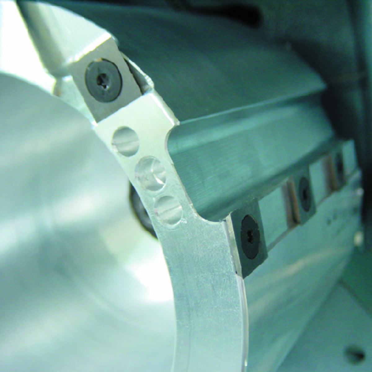 Close up of a notch cutter assembly showing an aluminum bracket and mounting screws